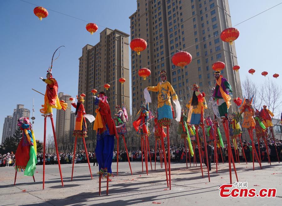 ?νθρωποι περπατο?ν σε ξυλοπ?δαρα σε μια παρ?λαση Σ?χουο στο Σιν?νγκ, στην επαρχ?α Τσινγκχ?ι, 29 Ιανουαρ?ου 2023. (Φωτογραφ?α / China News Service)