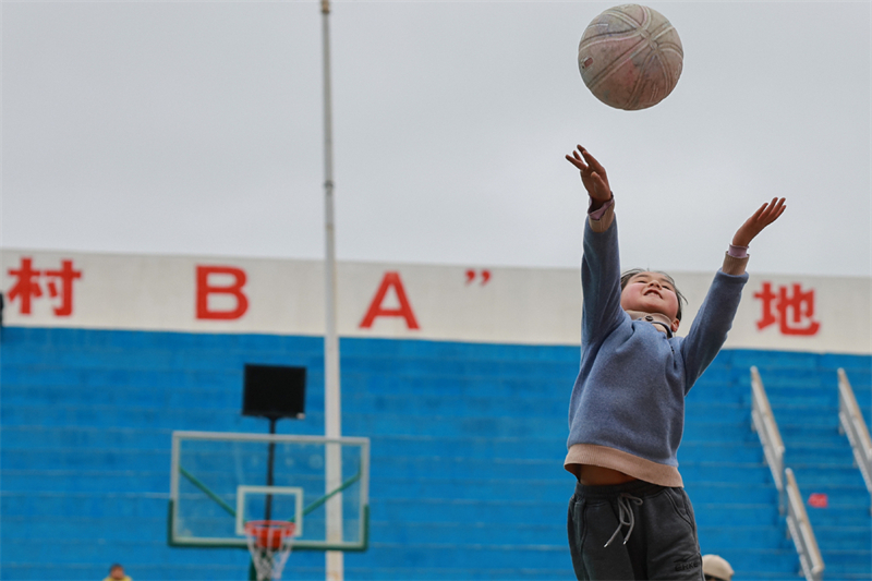 ?να παιδ? πα?ζει μπ?σκετ στο χωρι? Τ??παν, στην επαρχ?α Τ??τζιανγκ, στην επαρχ?α Γκου??ζοου τη? νοτιοδυτικ?? Κ?να?, στι? 25 Μαρτ?ου του 2023. (Φωτογραφ?α / Xinhua)