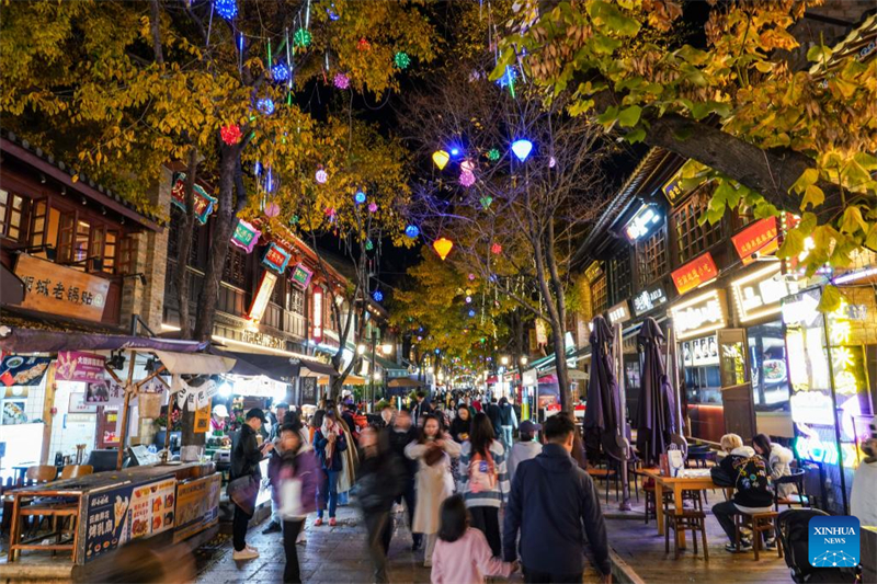 Τουρ?στε? περπατο?ν σε εμπορικ? δρ?μο τη ν?χτα στην π?λη Κουνμ?νγκ, στην επαρχ?α Γιουνν?ν τη? νοτιοδυτικ?? Κ?να?, στι? 6 Δεκεμβρ?ου 2024. (Φωτογραφ?α / Xinhua)