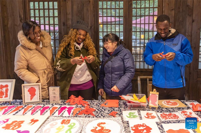 Φοιτητ?? απ? το εξωτερικ? προσπαθο?ν εξασκηθο?ν στην αρχα?α κινεζικ? παραδοσιακ? τ?χνη τη? κοπ?? του χαρτιο? αρχα?α π?λη Πι?νιαν, στην περιοχ? Μπ?ιμπ?ι, στο δ?μο Τσονγκκ?νγκ τη? νοτιοδυτικ?? Κ?να?, στι? 7 Ιανουαρ?ου 2025. (Φωτογραφ?α / Xinhua)