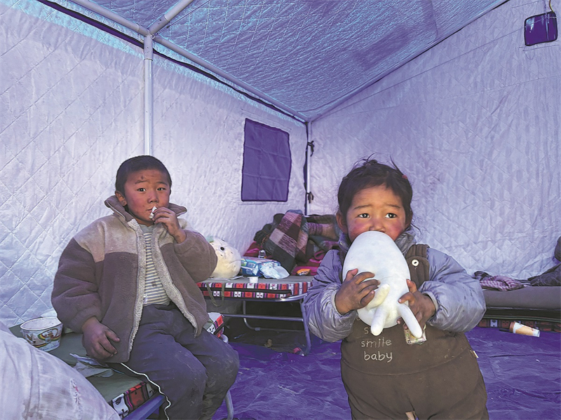 Παιδι? σε μ?α απ? τι? πρ?χειρε? σκην?? που ?χουν στηθε? σε δι?φορα σημε?α για την προστασ?α των σεισμ?πληκτων τη? περιοχ??. Π?μπτη 9/1/2025 στο χωρι? Τρ?κτσο?νγκ. Φωτογραφ?α: China Daily