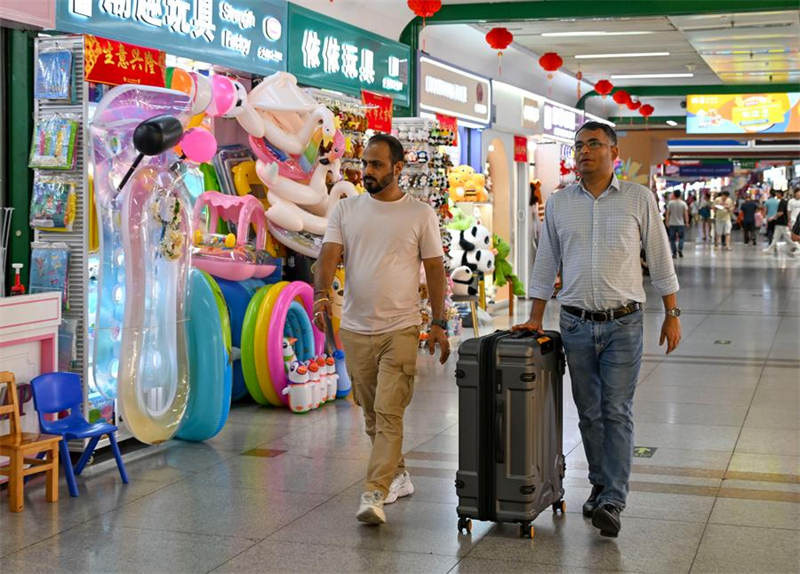 Ξ?νοι μεταφ?ρουν μια βαλ?τσα με δε?γματα προ??ντων στο Διεθν?? Εμπορικ? Κ?ντρο τη? Γιγο?, στην επαρχ?α Τζετζι?νγκ, στι? 16 Μα?ου του 2025. (Φωτογραφ?α / Xinhua)