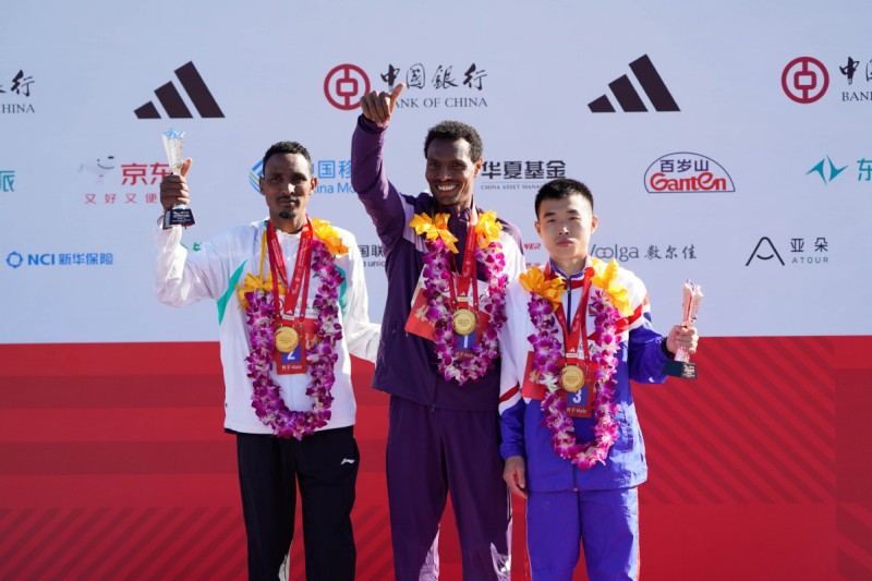 Ο νικητ?? Λ?μι Μπερχ?νου Χ?ιλε (C) απ? την Αιθιοπ?α ποζ?ρει με τον δε?τερο Ντεσαλ?ν Γκ?ρμα Ντεμπ?λ (L) απ? την Αιθιοπ?α και τον τρ?το Χαν ?λ Ριονγκ απ? τη Λα?κ? Δημοκρατ?α τη? Κορ?α? (DPRK) κατ? τη δι?ρκεια τη? τελετ?? απονομ?? των μεταλλ?ων για τον μαραθ?νιο ανδρ?ν στο Μαραθ?νιο του Πεκ?νου 2025 στο Πεκ?νο, στι? 2 Νοεμβρ?ου 2025. [Φωτογραφ?α/Xinhua]
